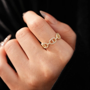 Macro shot of gold plated zircon pig nose ring on model finger with black background