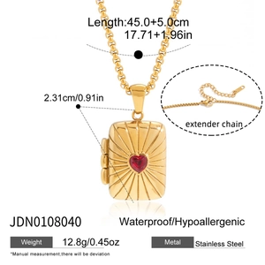 Détail du collier en acier doré 18K avec médaillon soleil et gemme coeur rouge
