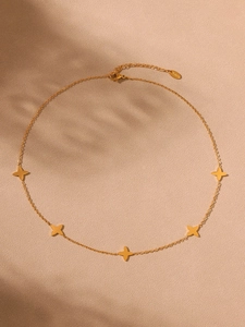 Detailed macro view of 18k gold plated stainless steel four-leaf clover chain and clasp
