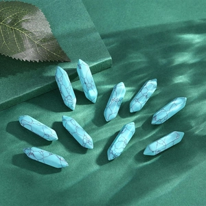 Polished hexagonal turquoise crystal stone pendants with black veins on dark background