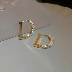 Boucles d'oreilles créoles dorées en forme de D avec zircons blancs style minimaliste