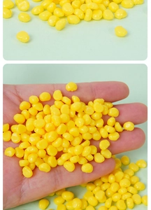 Close-up of miniature artificial corn kernels held in hand to show the small size