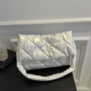 Chic silver quilted shoulder bag with shiny puffy finish for women on black desk