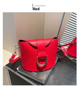Close-up of red PU leather bucket bag with gold metal buckle and adjustable strap