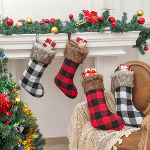 Classic red and black plaid Christmas stockings with faux fur trim hanging on fireplace