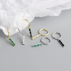 Macro shot of S925 silver ear hoops with rectangular zircon stones in green and black