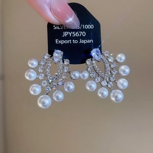 Detailansicht von 925er Silberohrringen mit Vintage-Perlen und funkelnden Zirkonia-Steinen