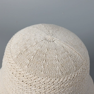 Detailed top view of beige knitted sun hat with intricate radial mesh pattern and texture