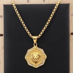 Detailed view of a gold lion head pendant with crystal accents on a box chain