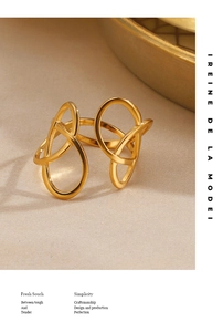 Close-up of golden hollow intertwined geometric ring on a beige textured cloth background