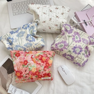 Flat lay of floral canvas zipper pouches with assorted flower prints and retro aesthetic
