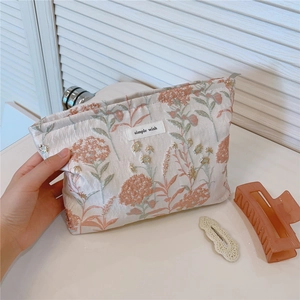 Detail of canvas makeup bag with floral embroidery and Simple Wish fabric label