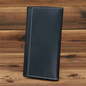 Detailed view of matte dark blue leather long wallet with contrast white stitching detail