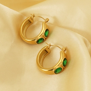 Detail of 18K gold-plated chunky hoop earrings with green oval cubic zirconia stones