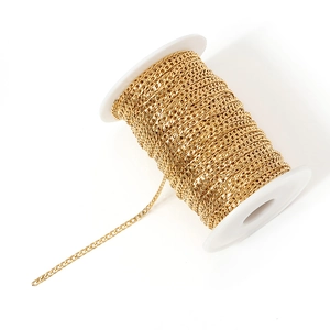 Detail of golden stainless steel Cuban chain neatly wound on a plastic spool for DIY jewelry