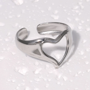 Vue macro de la bague coeur ajourée en acier inoxydable poli argenté brillant