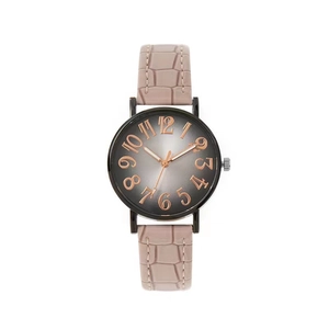 Détail de montre à quartz avec chiffres or rose et bracelet rose à motif crocodile