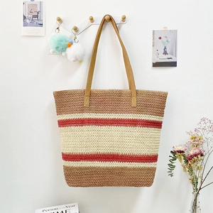 Detail of striped woven straw tote bag in brown and beige with leather shoulder straps