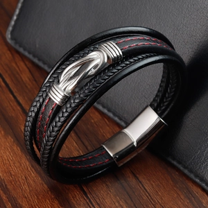 Nahaufnahme eines mehrlagigen Lederarmbands mit roten Nähten und Magnetverschluss
