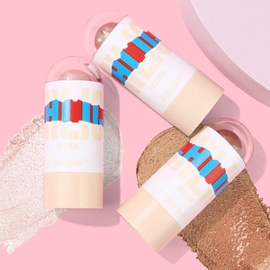 Drei schimmernde Highlighter-Sticks auf rosa Hintergrund mit cremiger Textur-Probe
