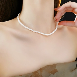Élégant collier de perles blanches présenté sur un modèle avec un fond sombre