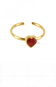 Macro detail of gold plated heart ring with red zircon inlay and stainless steel texture