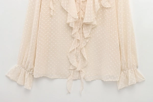 Detail of apricot ruffle chiffon blouse featuring 3D polka dot texture and sleeve detail