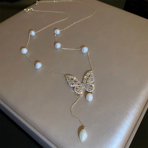 Gold plated butterfly necklace with freshwater pearls and sparkling zircon on silk