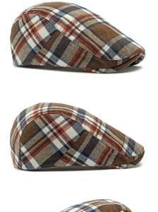 Detail of vintage brown plaid newsboy cap showing cotton blend texture and flat brim