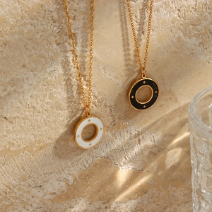 Detail of gold starburst pendants with black and white enamel on a textured stone wall
