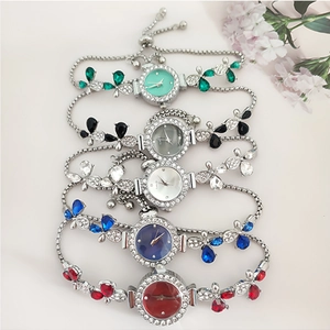 Flat lay of flower-shaped jeweled watches in five colors with rhinestone details