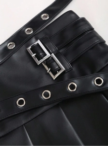 Detail of high waist black PU leather skirt with silver metal buckles and eyelet belt