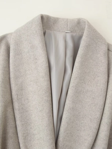 Detailed close-up of light gray wool coat lapel and high-quality fabric texture