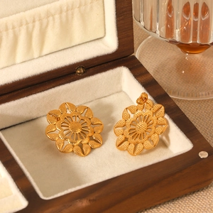 Boucles d'oreilles fleurs ajourées dorées vintage dans un écrin à bijoux en bois