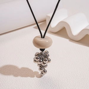 Detail of resin ring pendant with silver grape beads on a black wax cord necklace