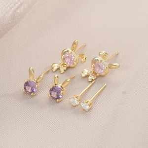 Vue détaillée des boucles d'oreilles lapin avec pierres de zircone violettes, roses et blanches
