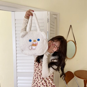Detail of white plush handbag with cute bear ears and blue-eyed embroidery