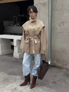 Detail of khaki oversized trench coat with wide sleeves and matching waist tie belt