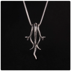 Gros plan d'un pendentif serpent en argent avec texture métallique sur fond noir