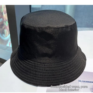 Detail of reversible black bucket hat showing twill fabric texture and reinforced stitching