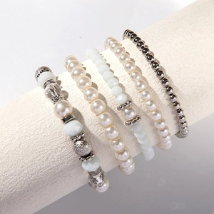 Dettaglio di un set di 5 braccialetti impilabili con perle sintetiche e cristalli