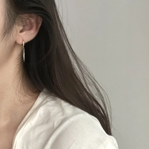 Close-up of minimalist S925 sterling silver long spike earrings on model's ear