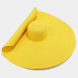 Detailed close-up of wide-brim straw hat in vibrant yellow with natural weave texture