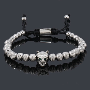 Detail of beaded wolf head bracelet with green zircon eyes and adjustable woven cord