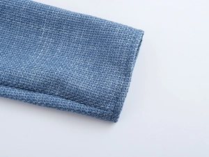 Nahaufnahme der blauen Tweed-Stofftextur und präzisen Nähte am eleganten Kleid