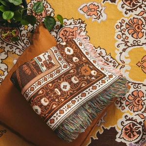 Detailed view of bohemian woven blanket with geometric jacquard patterns and fringed edges