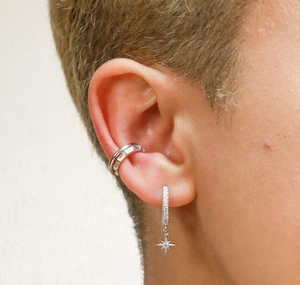 Detail of silver S925 sterling silver star earring with sparkling zircon on earlobe