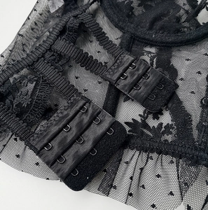 Close-up of the three-row hook-and-eye closure on a black lace embroidered lingerie bra