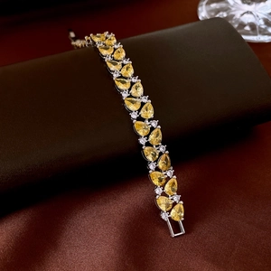 Détail du bracelet argenté avec pierres jaunes taille poire et zircons blancs
