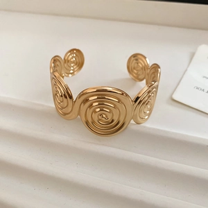 Macro detail of the golden spiral pattern cuff bracelet with high-polish mirror finish